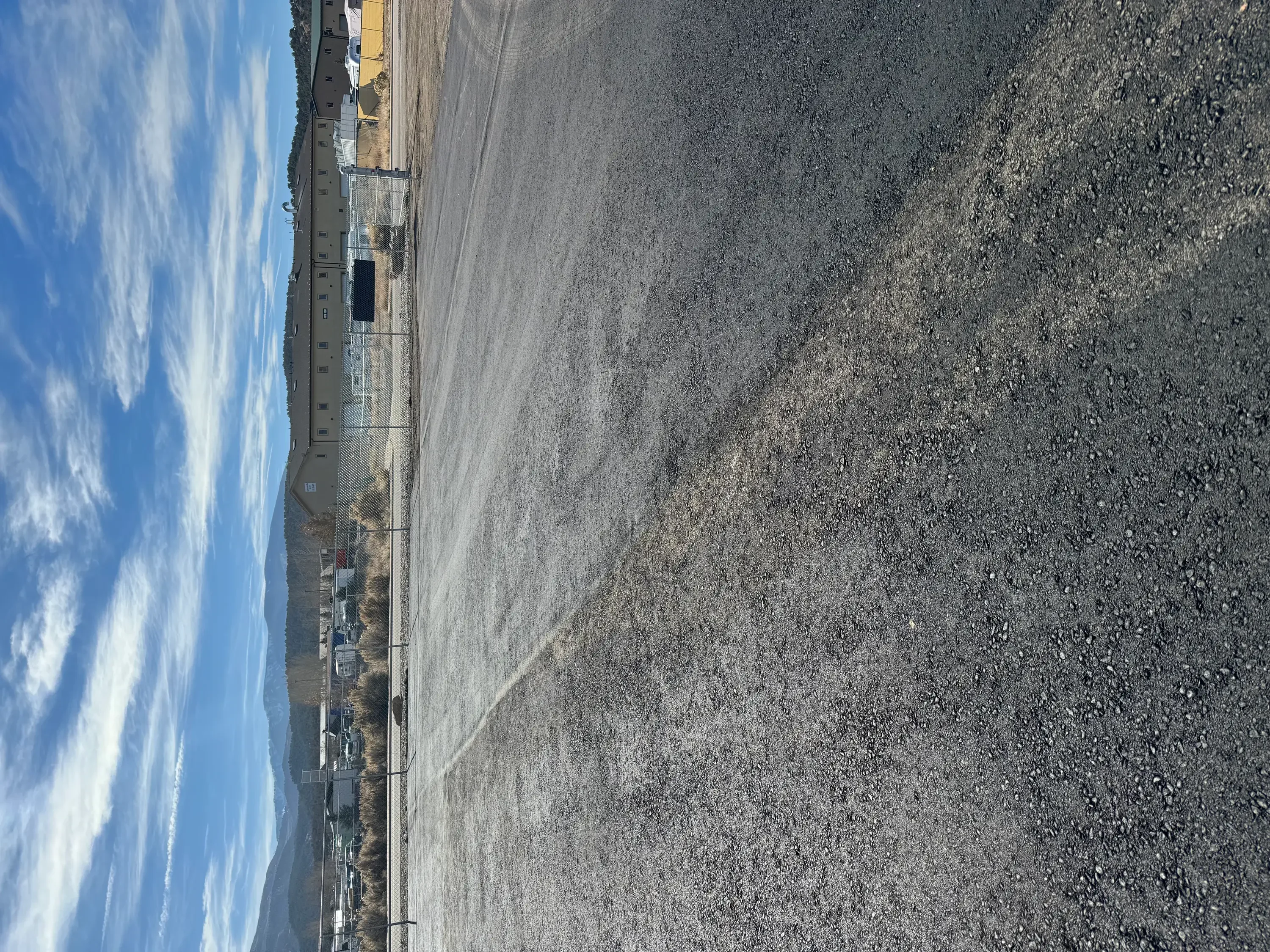 Freshly paved asphalt surface with dark aggregate and uniform grading on commercial lot