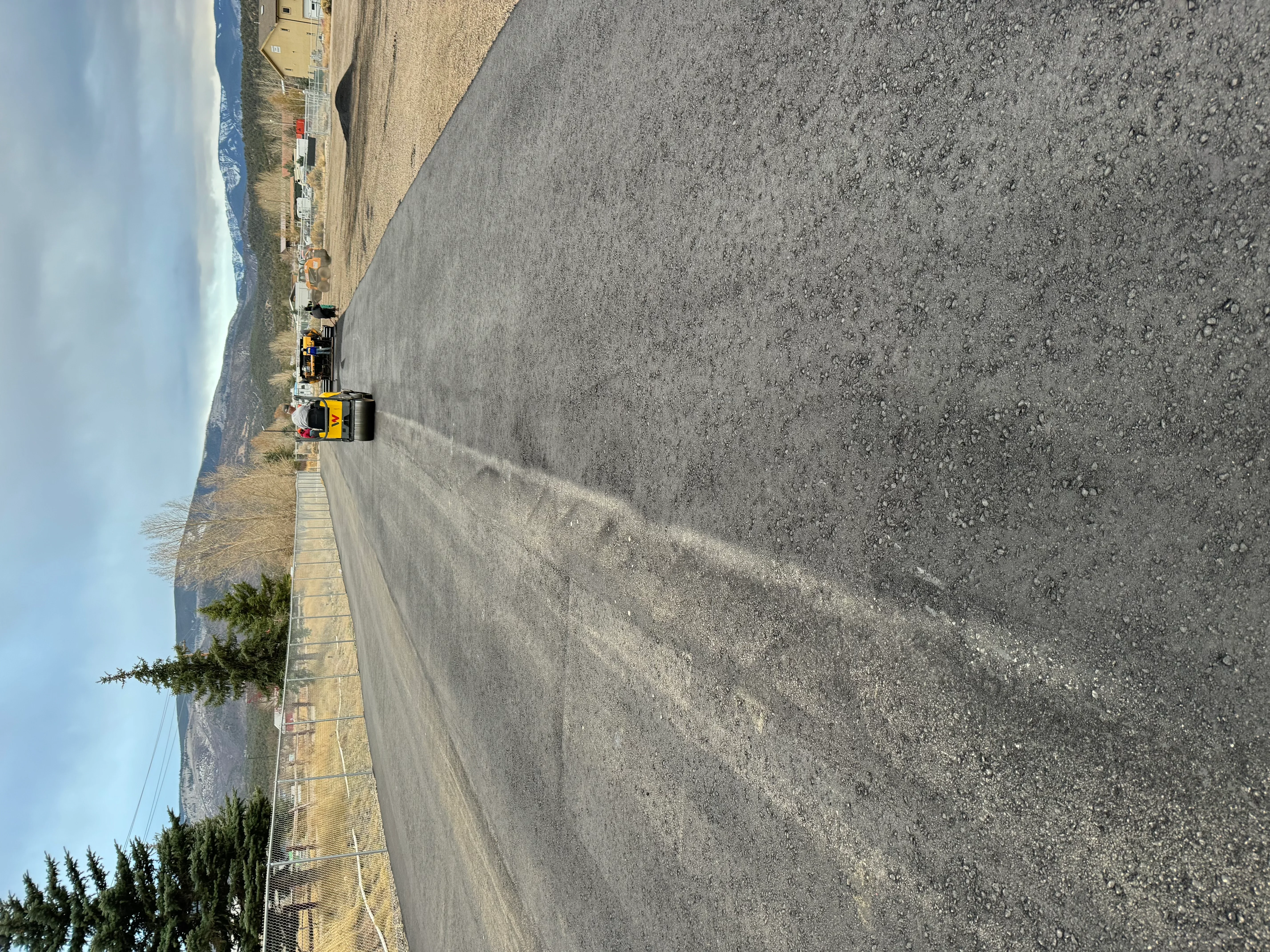 Newly paved asphalt driveway with yellow edge and center line markings